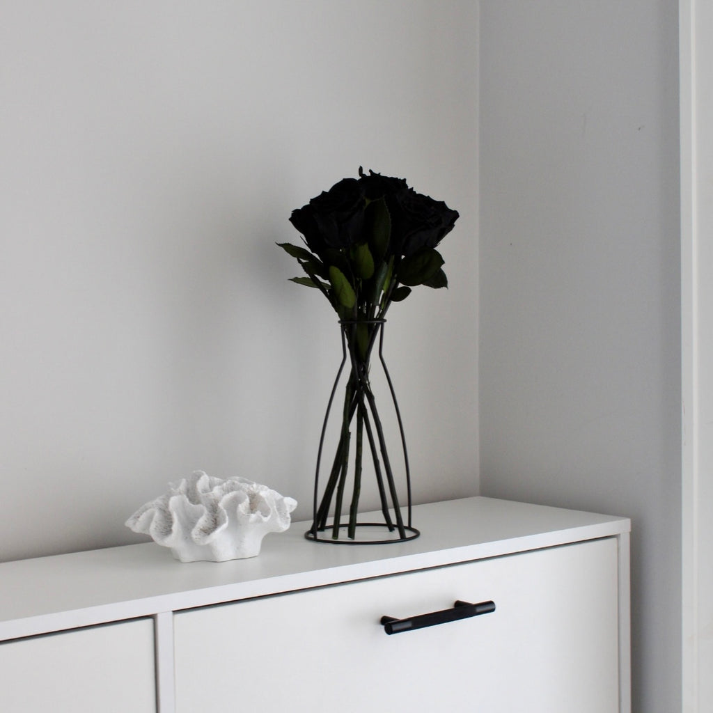 Black preserved long stem eternity roses with smooth, velvety petals in a rich, deep black. The roses maintain their natural beauty and elegant appearance, offering a striking and lasting touch for any arrangement or display.