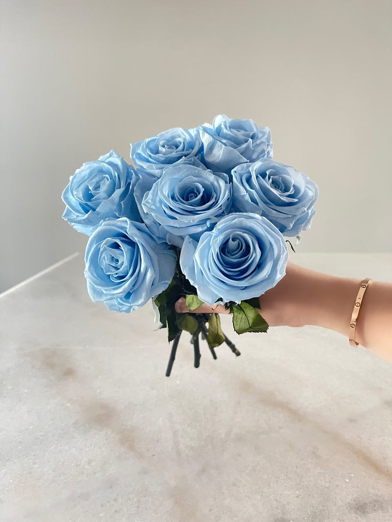 Luxurious light blue long-stemmed preserved eternity roses, with soft, delicate petals in a serene pastel shade.